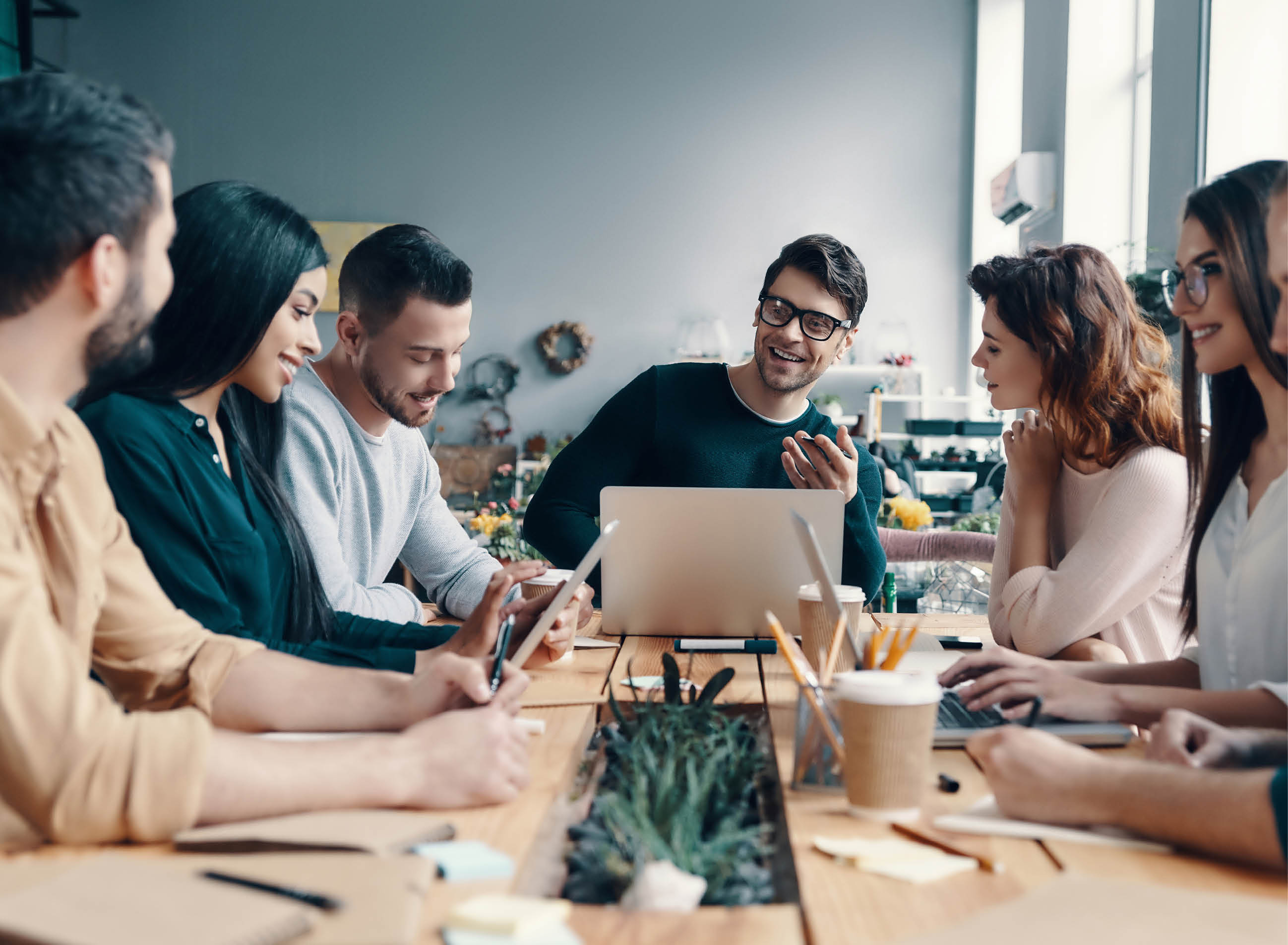 Marketing team. Group of young modern people in smart casual wear discussing something while working in the creative office             