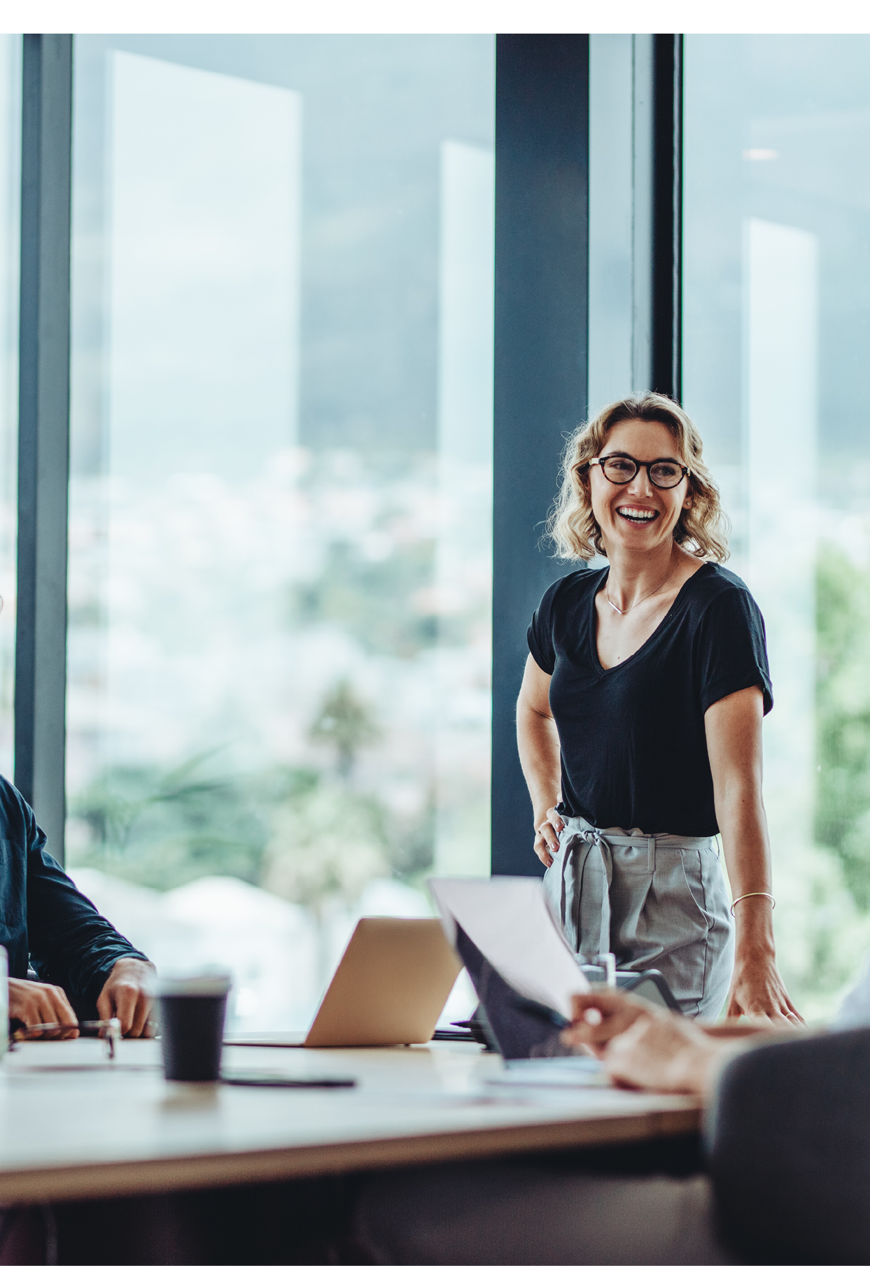 Office colleagues having casual discussion during meeting in conference room. Group of men and women sitting in conference room and smiling.