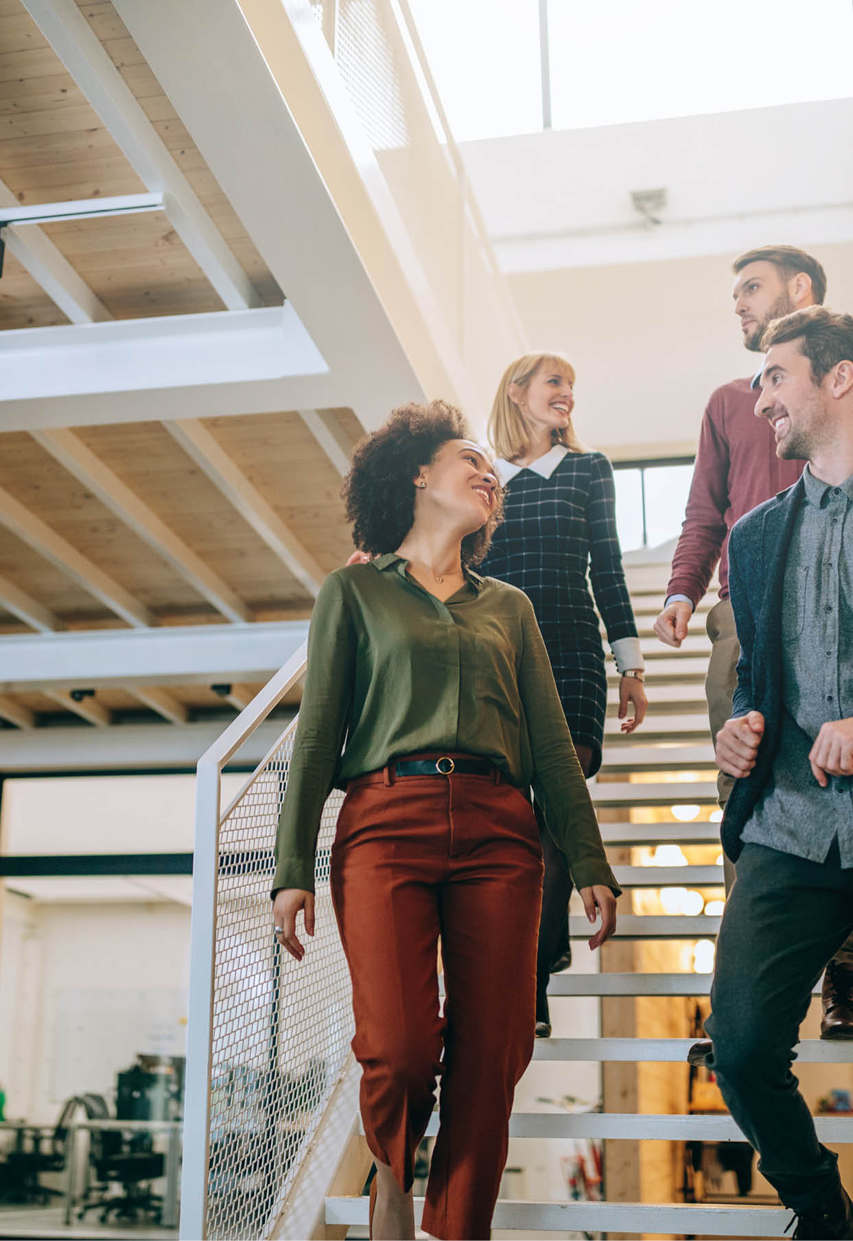 Group of diverse coworkers walking down the stairs in an office