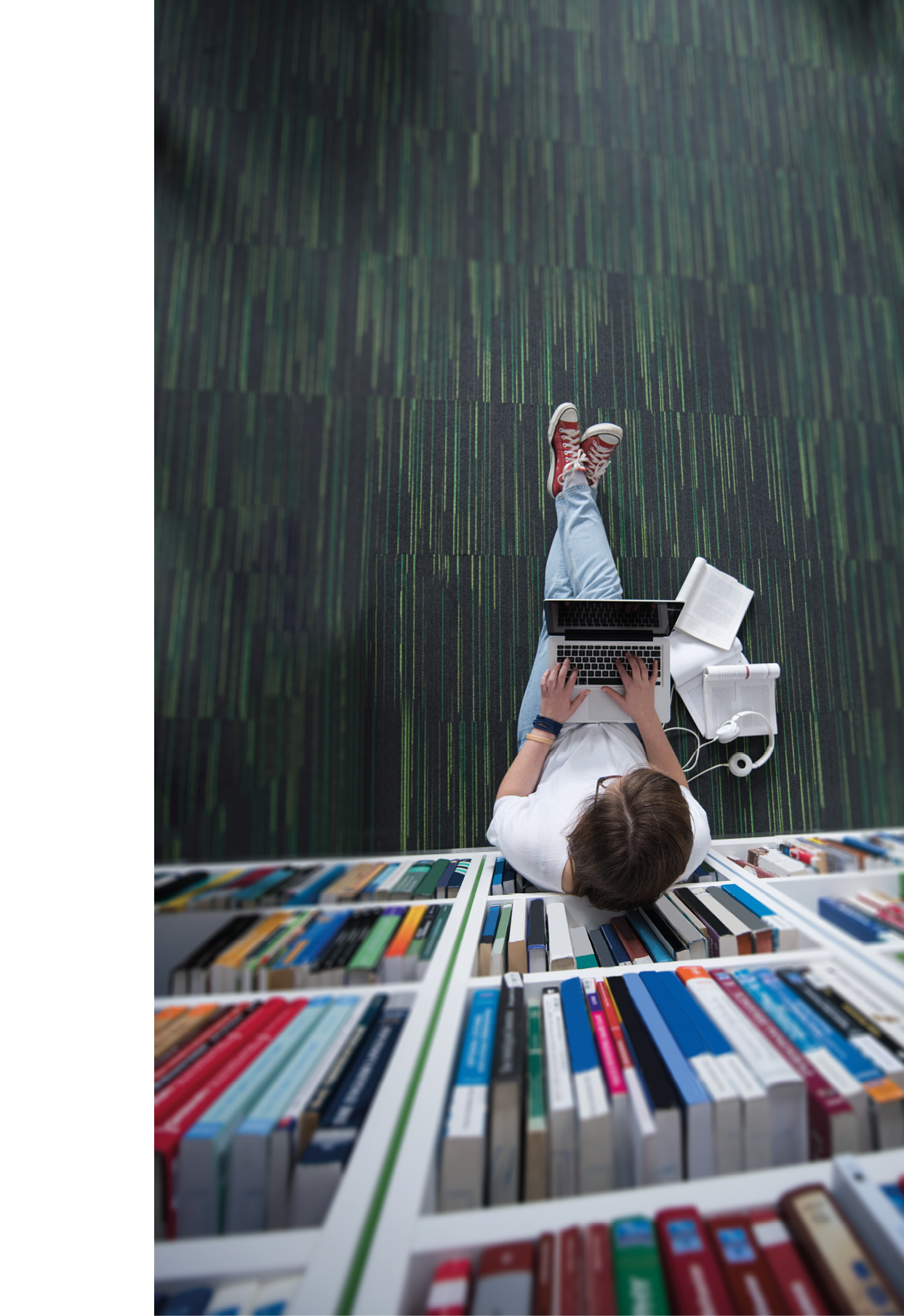 female student study in library using tablet and searching internet while Listening music and lessons on white headphones