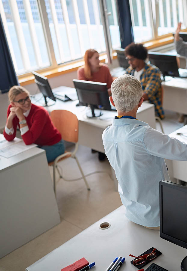Female professor explaining student's questions at an informatics lecture in the university computer classroom