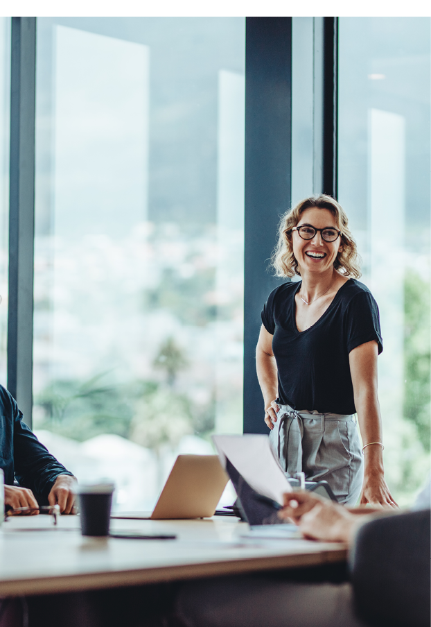 Office colleagues having casual discussion during meeting in conference room. Group of men and women sitting in conference room and smiling.