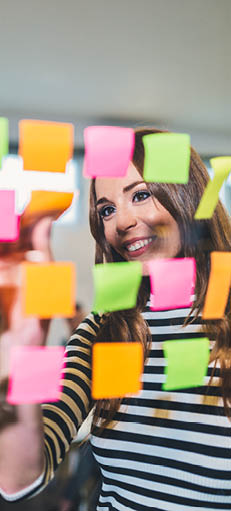  Businesswoman using Adhesive Notes on a glass