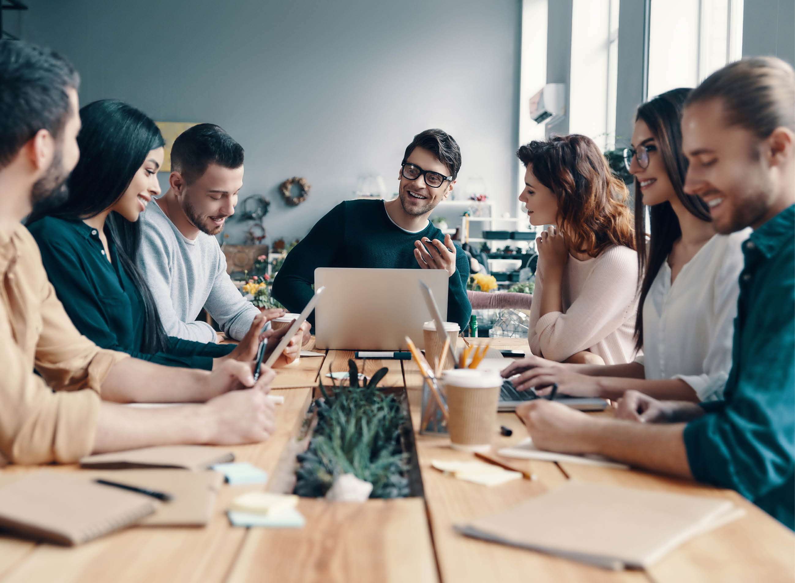 Marketing team. Group of young modern people in smart casual wear discussing something while working in the creative office             