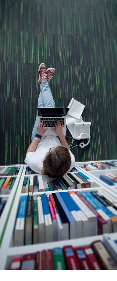 female student study in library using tablet and searching internet while  Listening music and lessons on white headphones