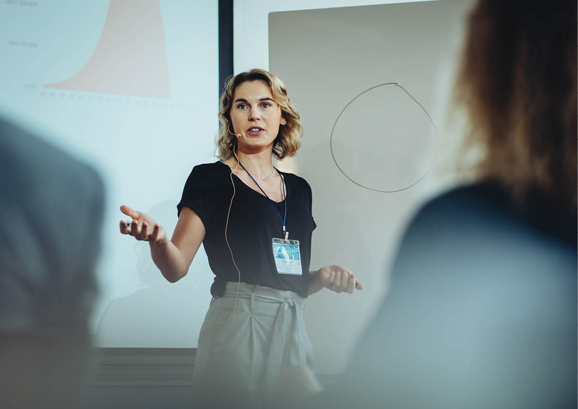 Woman presenting her idea to colleagues in meeting. Businesswoman public speaking in a conference meeting.