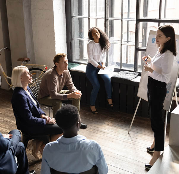 Top view concentrated different generations mixed race employees listening to skilled speaker, presenting new project or marketing strategy during educational workshop seminar at modern loft office.