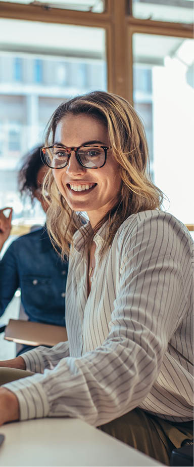 Female entrepreneur working on laptop and explaining strategy to attract followers to online web store while having meeting with colleagues in office.