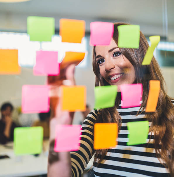  Businesswoman using Adhesive Notes on a glass
