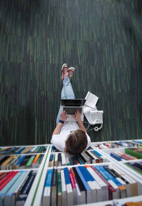 female student study in library using tablet and searching internet while Listening music and lessons on white headphones